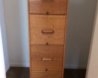 Vertical oak filing cabinet.