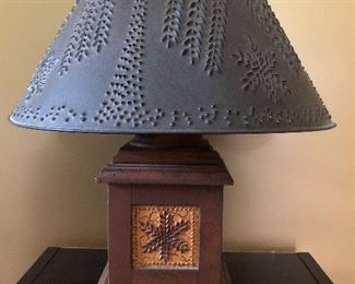 Table lamp with wood base and punched/carved metal shade.