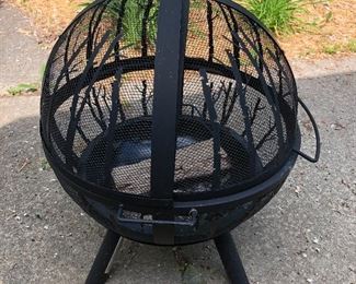 Spherical metal fire pit with trees/woods design.