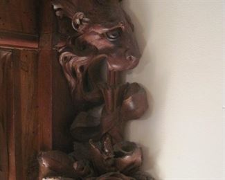 A pair of heavily carved wall columns with tiger heads and roses.