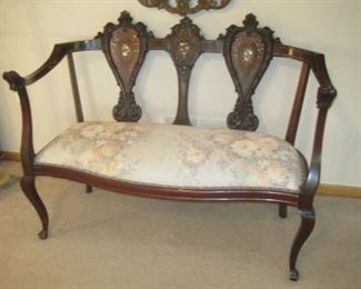A carved and inlaid Loveseat.