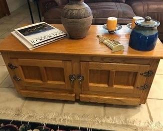 Classic, light wood coffee table with built in storage underneath. Assorted pottery pieces, both of these are signed. Coffee table books. 