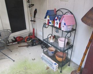 A cute wrought-iron shelf & fun patio decor. As well as lawn tools