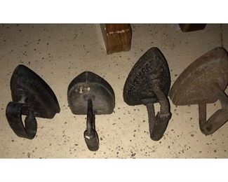 Many vintage cast iron items. Irons and assortment of skillets - some unusual.