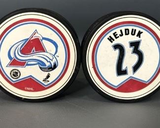 Two Colorado Avalanche Pucks, one autographed
