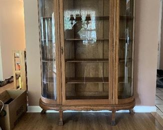 Antique Oak China Cabinet. Bowed glass side panels and glass door. Claw feet. Carved wood details at top. Four shelves. Perfect for displaying china or collectibles. Price negotiable.