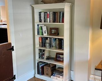 PAIR WHITE PAINTED BOOKSHELVES | Beautiful contemporary custom bookshelves with crown moldings, painted white; each h. 71 x 36 x 14 in.; two shelves being sold together, one in the house the other in a storage room 