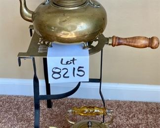 Lot 8215. $75.00. Three Piece Wood Handled brass warming stand (7" W x 14" T x 13" L) with a footed brass tea pot (JCB marking) with amber glass handle (10"w x 7"diam x 8" T) and a smaller amber glass handled footed tea pot (JCB marking). Very Rare Set.