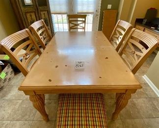 Lot 8261. $350.00. Knotty Pine Solid Wood Kitchen Table. It's a great workhorse of a table and includes 1 leaf and 6 chairs (one chair needs the seat pad to be resecured to the base). Light colored wood with column-ish style legs, the chair seats are a nice plaid with red, gold, cream seat pads. Normal usage wear. 61"l x 42"w x 31"t, 1 18" leaf, 6 chairs: 21"w x 27" d x 41"t to back