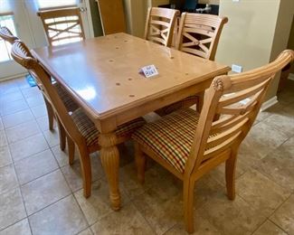 Lot 8261. $350.00. Knotty Pine Solid Wood Kitchen Table. It's a great workhorse of a table and includes 1 leaf and 6 chairs (one chair needs the seat pad to be resecured to the base). Light colored wood with column-ish style legs, the chair seats are a nice plaid with red, gold, cream seat pads. Normal usage wear. 61"l x 42"w x 31"t, 1 18" leaf, 6 chairs: 21"w x 27" d x 41"t to back