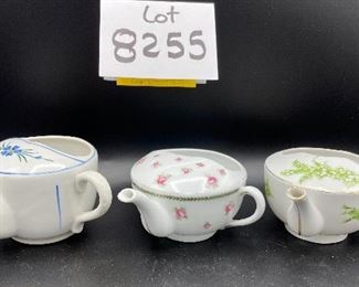 Lot 8255. $70.00. Lot of 7 side- handled infant/hospital/invalid feeders. All have a design and/or are colored in some way. 1) signed Vienna, Austria Edelweiss floral design,"Fur Genesung", which translates to "for recovery", 2) Cobalt blue color with floral images, 3) Purple violets, Vienna, Austria, 4) Pink rosebud design made in Victoria, Austria, 5) White with blue flower from London Covent Garden, 6) Lily of the Vally, marked #357, and 7) blue floral design embellishes the entire feeder cup.