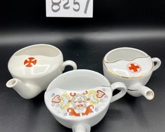 Lot 8257. $60.00. Lot of 6, side-handled infant/hospital/invalid feeders all with some design. 1) Red Cross, #4767 on bottom, 2) red, yellow & blue design and image of baby, 3) Red Cross/gold trim, marked "98" on bottom, 4) Pink & plum floral, marked "7317", 5) Purple floral with gold, 6) blue floral. Our favorite lot.