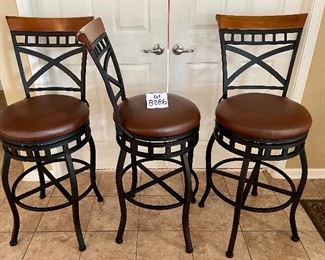 Lot 8286.$120.00 3 metal frame swivel bar stools from, 300 lb max.weight load, wood accent on back with faux brown leather seats. 45"t x 29" seat height x 18" dia