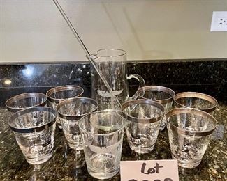 Lot 8323. $60.00 "Off we go into the Wild Blue Yonder...." a set of 8 silver rimmed Air Force Academy low-ball glasses and Stalag Luft pitcher with glass stirrer and a single low-ball glass.