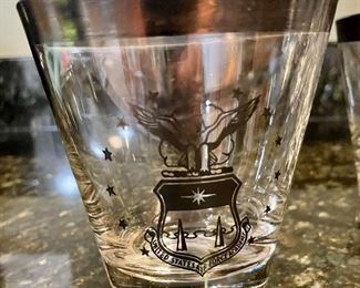 Lot 8323. $60.00 "Off we go into the Wild Blue Yonder...." a set of 8 silver rimmed Air Force Academy low-ball glasses and Stalag Luft pitcher with glass stirrer and a single low-ball glass.