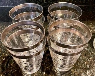 Lot 8323. $60.00 "Off we go into the Wild Blue Yonder...." a set of 8 silver rimmed Air Force Academy low-ball glasses and Stalag Luft pitcher with glass stirrer and a single low-ball glass.