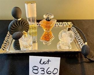 Lot 8360. $90.00 Perfume Lot includes: Mirrored dresser/vanity tray and opened perfume bottles including White Linen by Estee Lauder, Tresor by Lancome, a black perfume bottle and two bottles with atomizers.