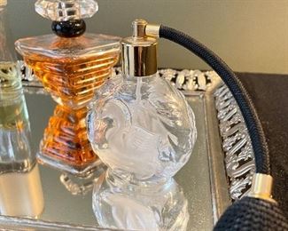 Lot 8360. $90.00 Perfume Lot includes: Mirrored dresser/vanity tray and opened perfume bottles including White Linen by Estee Lauder, Tresor by Lancome, a black perfume bottle and two bottles with atomizers.