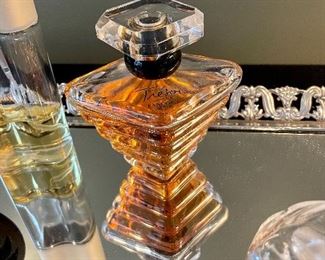 Lot 8360. $90.00 Perfume Lot includes: Mirrored dresser/vanity tray and opened perfume bottles including White Linen by Estee Lauder, Tresor by Lancome, a black perfume bottle and two bottles with atomizers.
