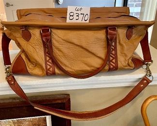 Lot 8370. $35.00 Leather structured duffle with reticulated cut leather accent design. Zipper closure with leather strap and handles. 24"L x 10"W 12" T