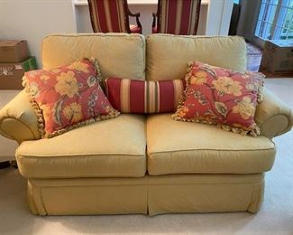 Two CR Laine love seats with two floral pillows each