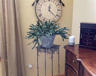 Wall clock, plant stand and live plant