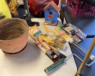Large variety of paint brushes and birdhouse