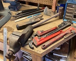 Bench vice, pipe wrenches, chisels, crowbars and cedar shake
