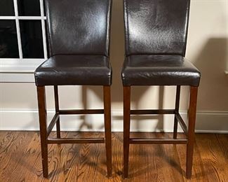 PAIR BAR STOOLS | Faux-leather upholstered high seats; some wear to seat material and wood frame; h. 46 x 18 x 20 in.; one with loose frame 