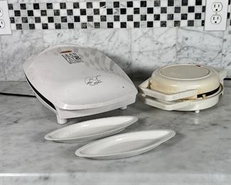 (2pc) KITCHEN IRON APPLIANCES | George Foreman's Lean Mean Fat Reducing Grilling Machine Model No. GR26 CB with original manual and fat catching trays and a Toastmaster Waffle Baker, both turn on when plugged in, both with signs of use 