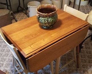 Drop Leaf Table and Chairs. Majolica style jardinière, stoneware crocks in the background.