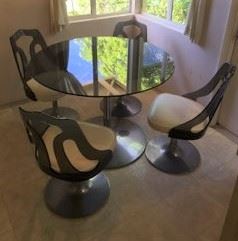 A nice round glass-top table and four matching chairs.