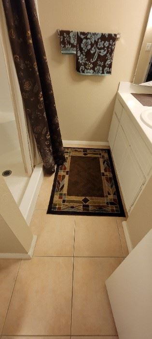 Decorative bath mat and shower curtain