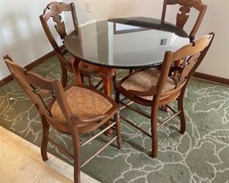 Small glass-top table with 4 cane-seat chairs
