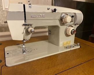 White sewing machine in cabinet 