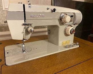 White sewing machine in cabinet