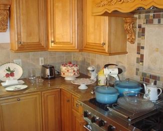 Kitchen:  Ceramic, glass dishes and cake stands are nestled among a HAMILTON BEACH two-slice toaster; a vintage metal JUICE KING; vintage SUNBEAM MIXMASTER;  and two cast iron/enameled TRAMONTINA pots with lids (4 quart and 7 quart).