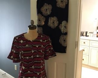 Master Bedroom-Closet:  A dark blue TRINA TURK dress with gold sparkles hangs on the door by a multi-color TRINA TURK dress.  Both are size 8.