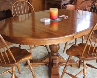 Round to oval table with 4 spindle back chairs.