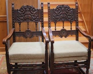 Two tall back heavily carved chairs.