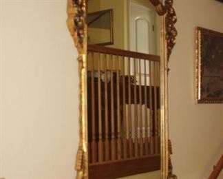 Large gold and gilt entry mirror with alabaster top on table.