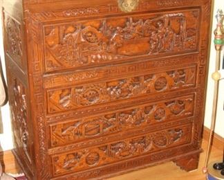 Heavily carved Asian themed chest with three drawers and trunk/chest at the top.
