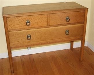 One of two honey oak three drawer chests.