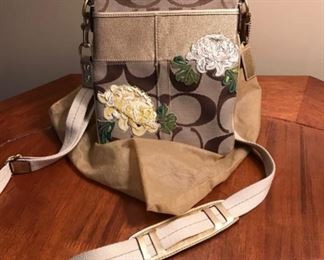 $75 - Coach C Logo and Floral Cross Body Bag  - This Coach handbag has never been worn. It is in excellent condition and features two floral details.