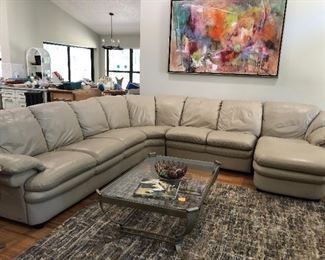 Natuzzi leather sectional in great condition!  Shown with glass and metal coffee table which has two matching lamp tables