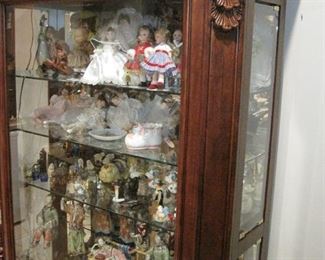 Display Cases full of collectibles and doll. Display Cases are for sale. 