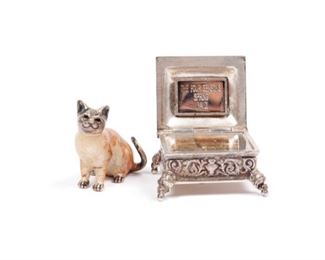 TWO DIMINUTIVE STERLING SILVERSMITH ARTICLES
A limited edition Royal Tunbridge Wells, England, and Reuge sterling silver music box with fine incised filigree decoration throughout, playing Vivaldi's Four Seasons and an enamel and dipped-silver cat by New Orleans Silversmiths.