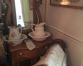 Oak wash stand with mirror and wash bowl and pitcher sets with quilt rack and table linens
