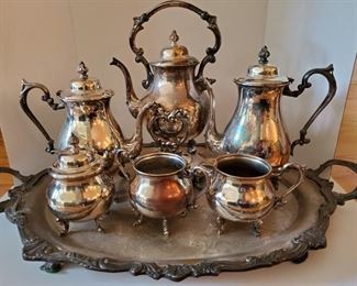Silver on copper tea and coffee set. Includes tray, sugar bowls, creamer, tea pot, coffee pot and a teapot on tilting stand with burner. Tray is large and heavy and measures 31x20"https://ctbids.com/#!/description/share/949929