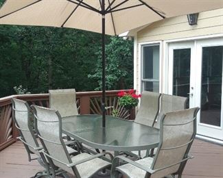 Outdoor dining table, umbrella and swivel chairs